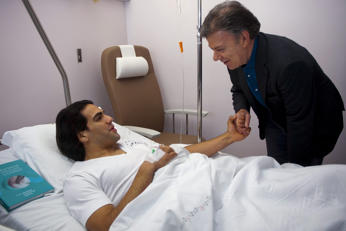 epa04041606 Colombian president Juan Manuel Santos (R) during his visit to Colombian soccer player Radamel 'Falcao' Garcia (L) who recovers from a knee surgery at Trinidade Hospital in Porto ...