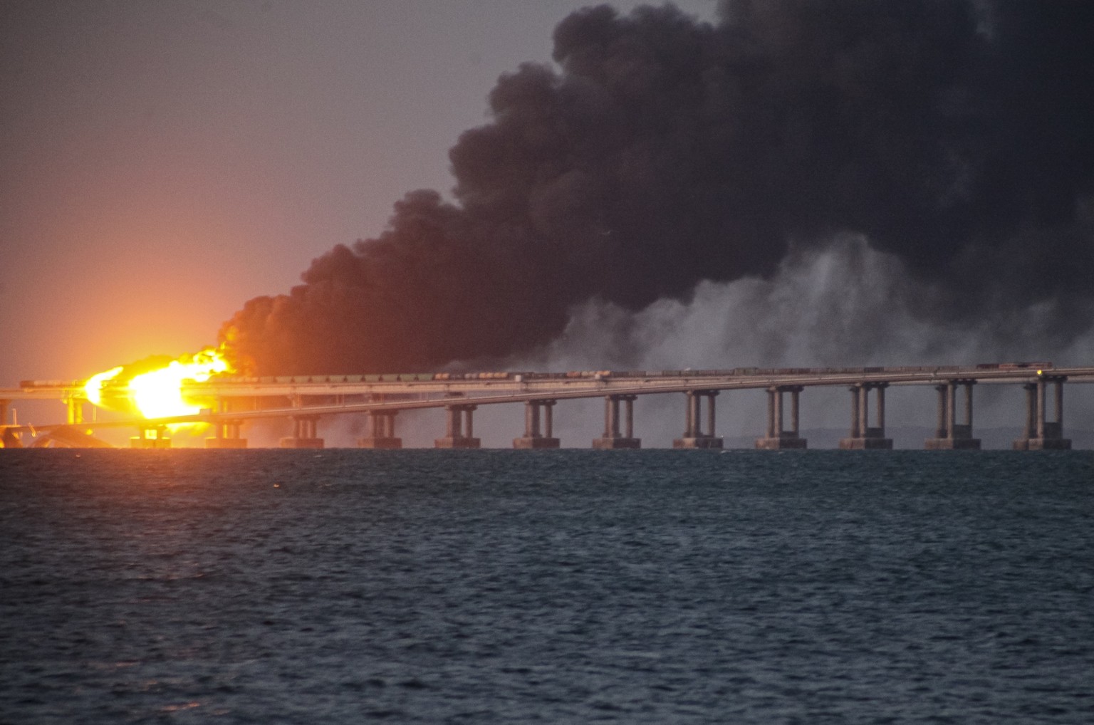 FILE - Flame and smoke rise from Crimean Bridge connecting Russian mainland and Crimean peninsula over the Kerch Strait, after what Russian authorities said was a bomb caused fire and partial collapse ...