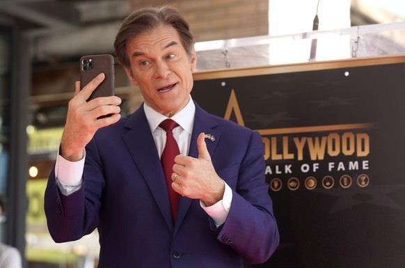 Mehmet Oz, the former host of &quot;The Dr. Oz Show,&quot; speaks on his camera phone before a ceremony honoring him with a star on the Hollywood Walk of Fame on Friday, Feb. 11, 2022, in Los Angeles. ...