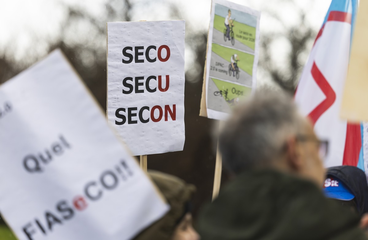 Une personne tient une pancarte ou l'on peut lire "SECO SECU SECON" lors d'un rassemblement a l'appel des syndicats genevois afin de soutenir les chomeurs ce mardi 3 fevrier 2 ...