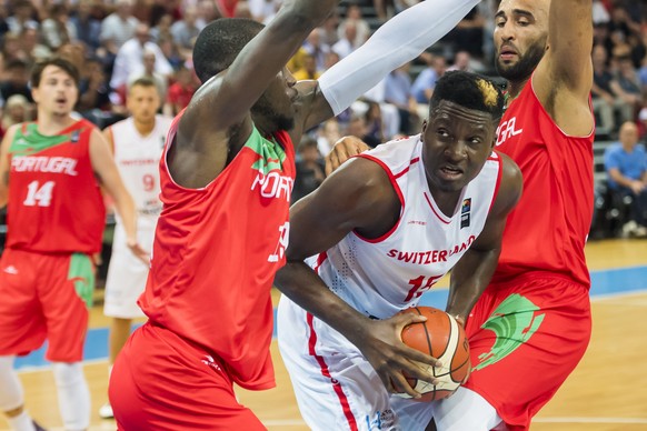 Switzerland?s Clint Capela, center, fights for the ball with Portugal?s Jeremiah Wilson, left, and Claudio Fonseca, right, during the FIBA Eurobasket 2021 pre-qualifiers match between Switzerland and  ...