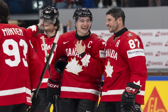 Canada's Macklin Celebrini. 2nd right, and Canada's Sidney Crosby, right, celebrate after winning the 2026 IIHF Men's Ice Hockey World Championship preliminary round group B game betwee ...