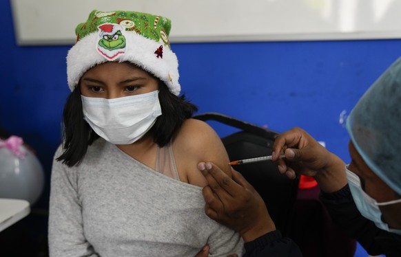 A child receives a dose of the Sinopharm COVID-19 vaccine during a vaccination campaign targeting children between the ages 5 -11, in La Paz, Bolivia, Thursday, Dec. 9, 2021. (AP Photo/Juan Karita)