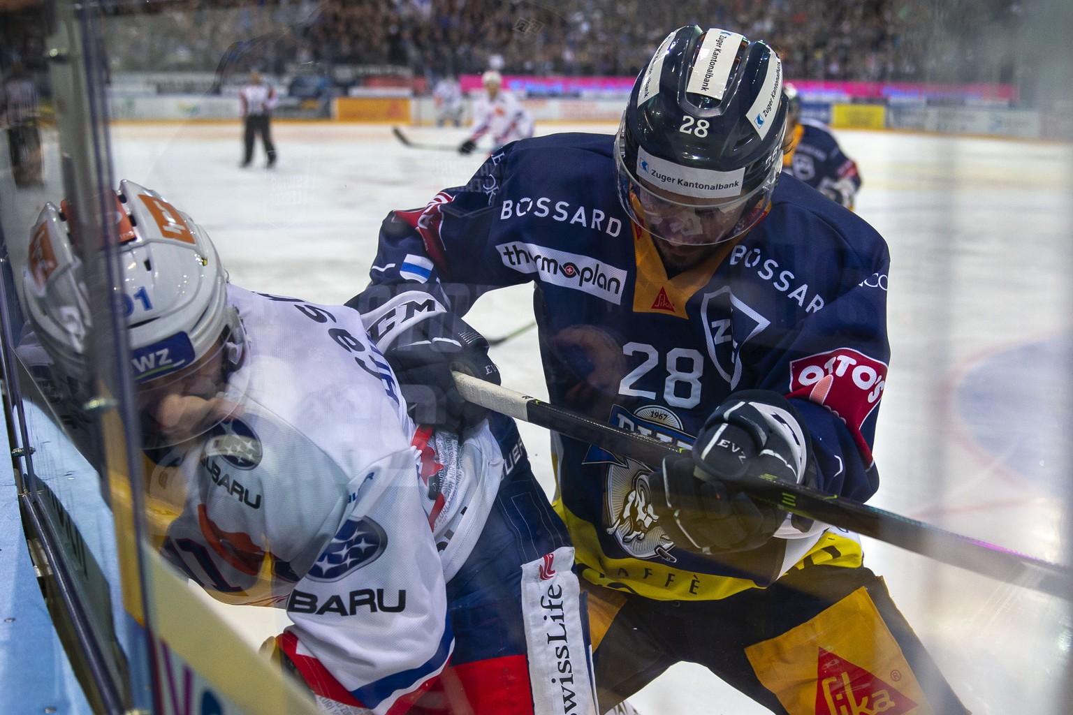 EV Zug Stuermer Yannick-Lennart Albrecht, rechts, gegen ZSC Lions Stuermer Denis Hollenstein waehrend dem Eishockey-Meisterschaftsspiel der National League zwischen dem EV Zug und den ZSC Lions am Fre ...