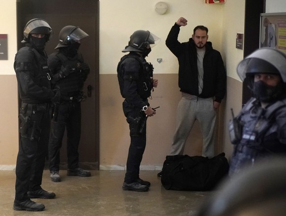 Rap singer Pablo Hasél reacts next to police officers before being detained at the University of Lleida, Spain, Tuesday, Feb. 16, 2021. A rapper in Spain and dozens of his supporters have locked thems ...