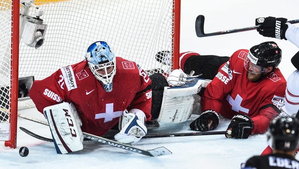 epa04742309 Switzerlandﾃ｢竄ｬ邃｢s Reto Berra (L) and Switzerlandﾃ｢竄ｬ邃｢s Timo Helbling in action during the Ice Hockey World Championship 2015 group A match between the Switzerland and Canada at O2 Arena  ...