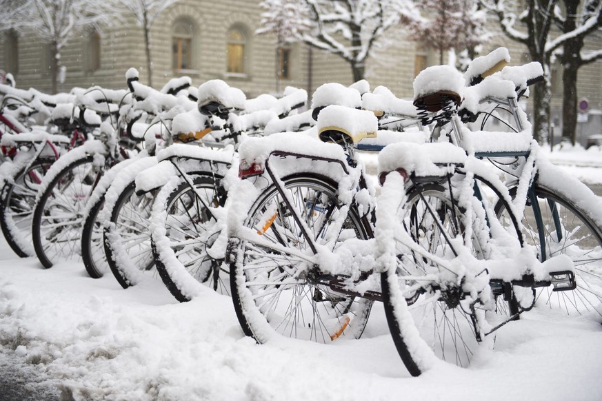 epa05709789 Bicycles are covered in heavy snowfall on a street side in Bern, Switzerland, this Tuesday, January 10, 2017. Switzerland has experienced fickle weather patterns this ski season, with some ...
