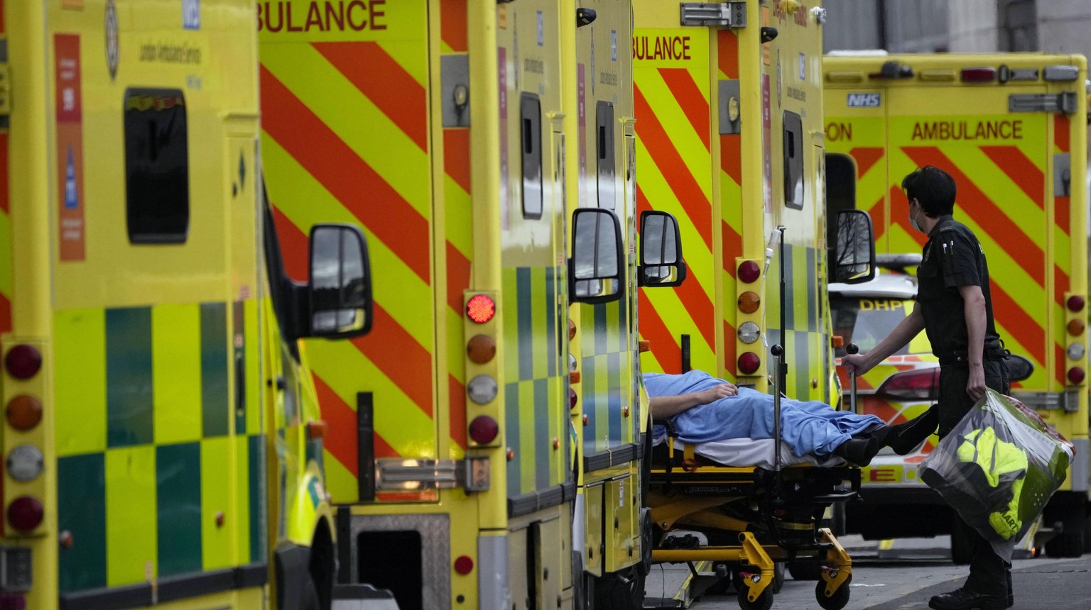 A patient is pushed on a trolley after arriving in an ambulance outside the Royal London Hospital in the Whitechapel area of east London, Thursday, Jan. 6, 2022. Health authorities across the U.K. sim ...