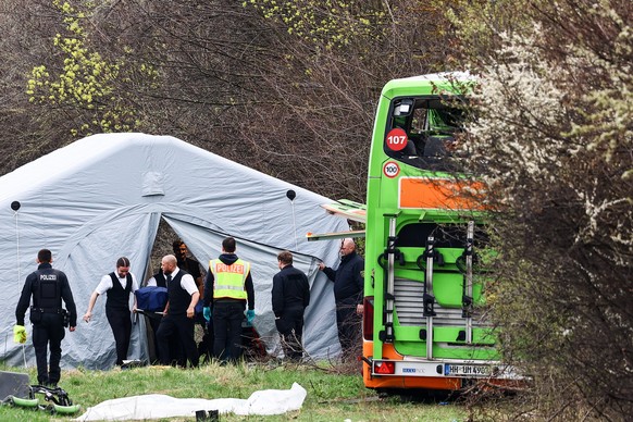 epa11247032 The body of a victim is removed from the scene of a bus accident on the A9 highway in Schkeuditz, near Leipzig, Germany, 27 March 2024. At least five people died and several others were in ...