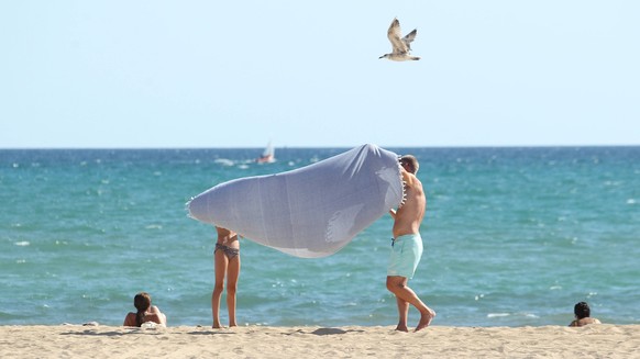 Ein Mann und eine Frau stehen bei Temperaturen über 35 Grad am Strand von Playa de Palma. Mallorca Spanien *** A man and a woman stand on the beach of Playa de Palma Mallorca Spain in temperatures abo ...