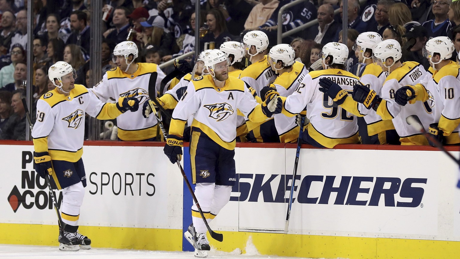 Nashville Predators&#039; Mattias Ekholm (14) celebrates with the bench after he scored against the Winnipeg Jets during the second period of an NHL hockey game Tuesday, Feb. 27, 2018, in Winnipeg, Ma ...