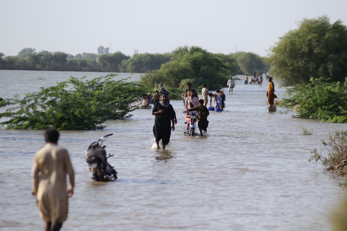 epa12398382 Locals in Unnar Pur wade through floodwater in Hyderabad, Pakistan, 22 September 2025. Floodwaters have surrounded Unnar Pur, Manzoorabad, and Budha Pur near Jamshoro, leaving several vill ...