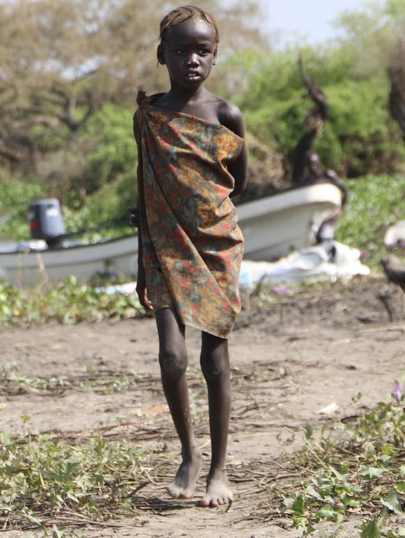 In this Wednesday Dec. 16 2020 photo, a young girl stands near the river in Lekuangole, South Suday, South Sudan is one of four countries with areas that could slip into famine, the United Nations has ...