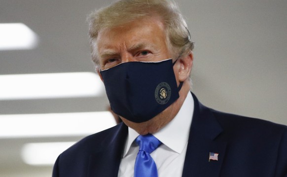 FILE - In this July 11, 2020, file photo President Donald Trump wears a face mask as he walks down a hallway during a visit to Walter Reed National Military Medical Center in Bethesda, Md. On Tuesday, ...