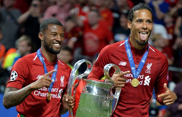 epa07619179 Georginio Wijnaldum (L) and Virgil Van Dijk of Liverpool FC celebrate after winning the UEFA Champions League final between Tottenham Hotspur and Liverpool FC at the Wanda Metropolitano st ...