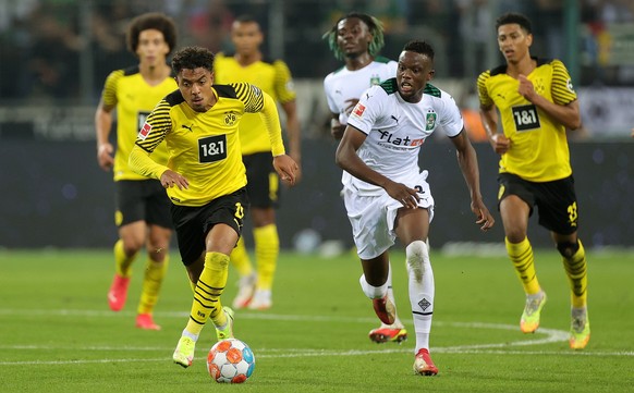epa09488060 Dortmund's Donyell Malen (L) in action against Moenchengladbach's Denis Zakaria (R) during the German Bundesliga soccer match between Borussia Moenchengladbach and Borussia Dortmund at Borussia-Park in Moenchengladbach, Germany, 25 September 2021.  EPA/FRIEDEMANN VOGEL CONDITIONS - ATTENTION: The DFL regulations prohibit any use of photographs as image sequences and/or quasi-video.