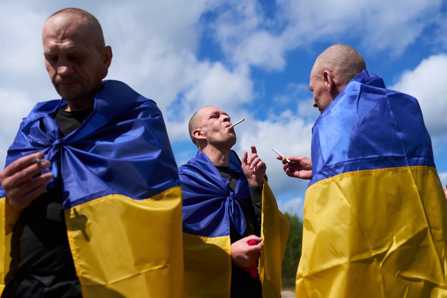 Ukrainian soldiers smoke after returning from captivity after a Prisoners of War (POWs) exchange between Russia and Ukraine, in Chernihiv region, Ukraine, Wednesday, Aug. 19, 2026. (AP Photo/Francisco ...