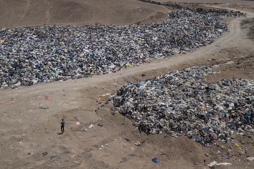 A large pile of second-hand clothing covers the sand near La Mula neighborhood in Alto Hospicio, Chile, Monday, Dec. 13, 2021. Chile is a big importer of second hand clothing, and unsold clothing gets ...