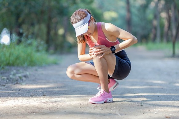 Frau verletzt sich beim Joggen.