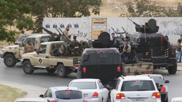 FILE - In this Sunday, May 18, 2014 file image made from video provided by the Libyan national army via AP Television, vehicles with heavy artillery of the Tripoli joint security forces move closer to ...