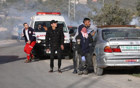 epa08285428 Palestinian protesters seek cover during clashes with Israeli troops at Beta village near the West Bank city of Nablus, 11 March 2020. According to media reports, 20 Palestinians were woun ...