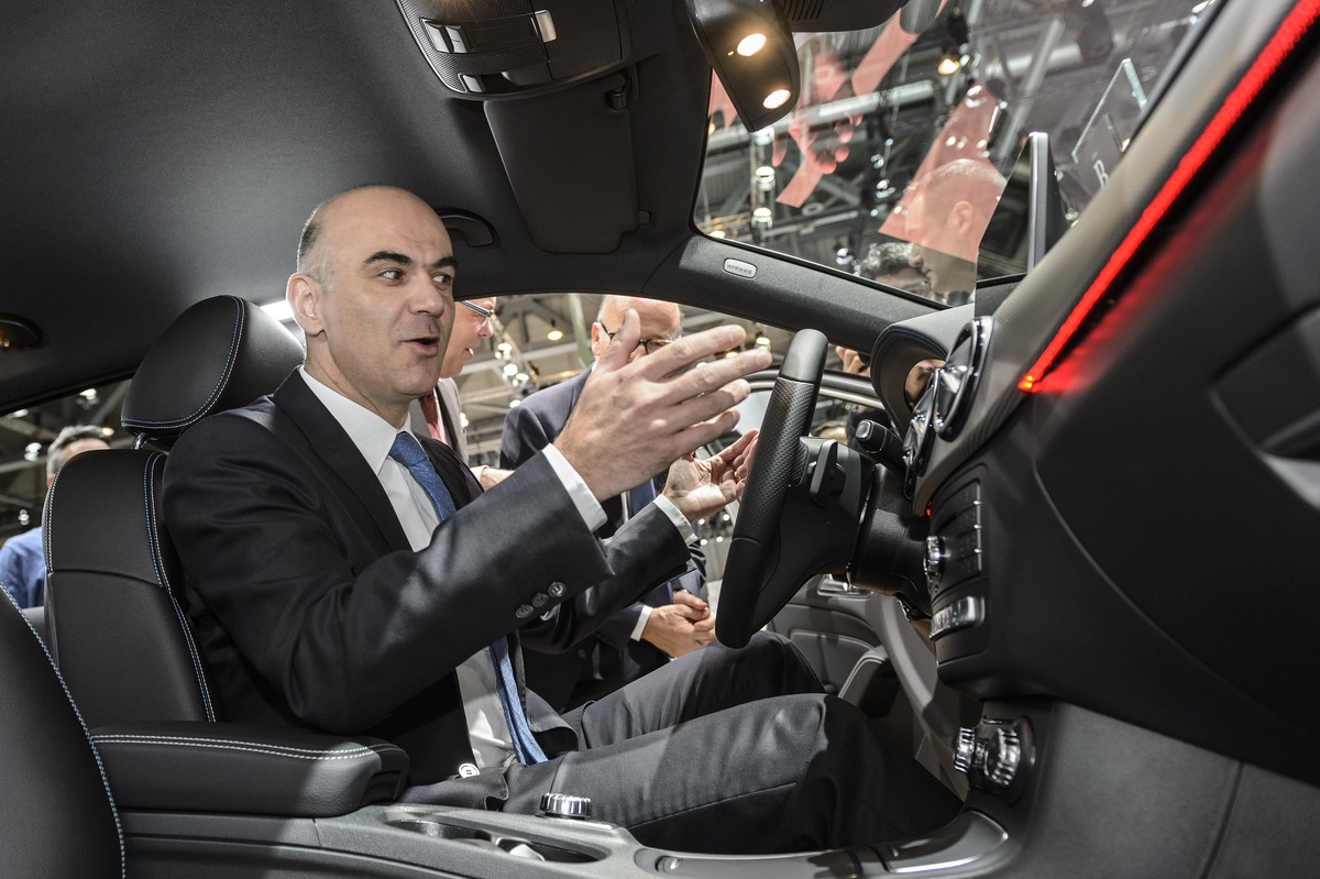 Swiss federal Councillor Alain Berset, left, sits in a Mercedes car shown by Marcel Guerry, CEO of Mercedes-Benz Switzerland, right, during the opening of the 86th Geneva International Motor Show in G ...