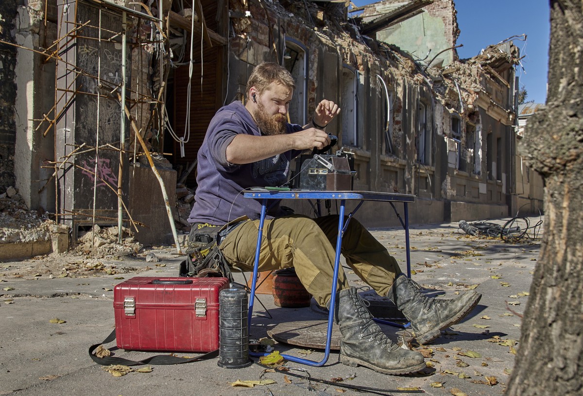 epa10251070 A specialist restores a fiber optic communication near destroyed in shelling an administrative building in Kharkiv, northeastern Ukraine, 18 October 2022. The Ukrainian army pushed Russian ...