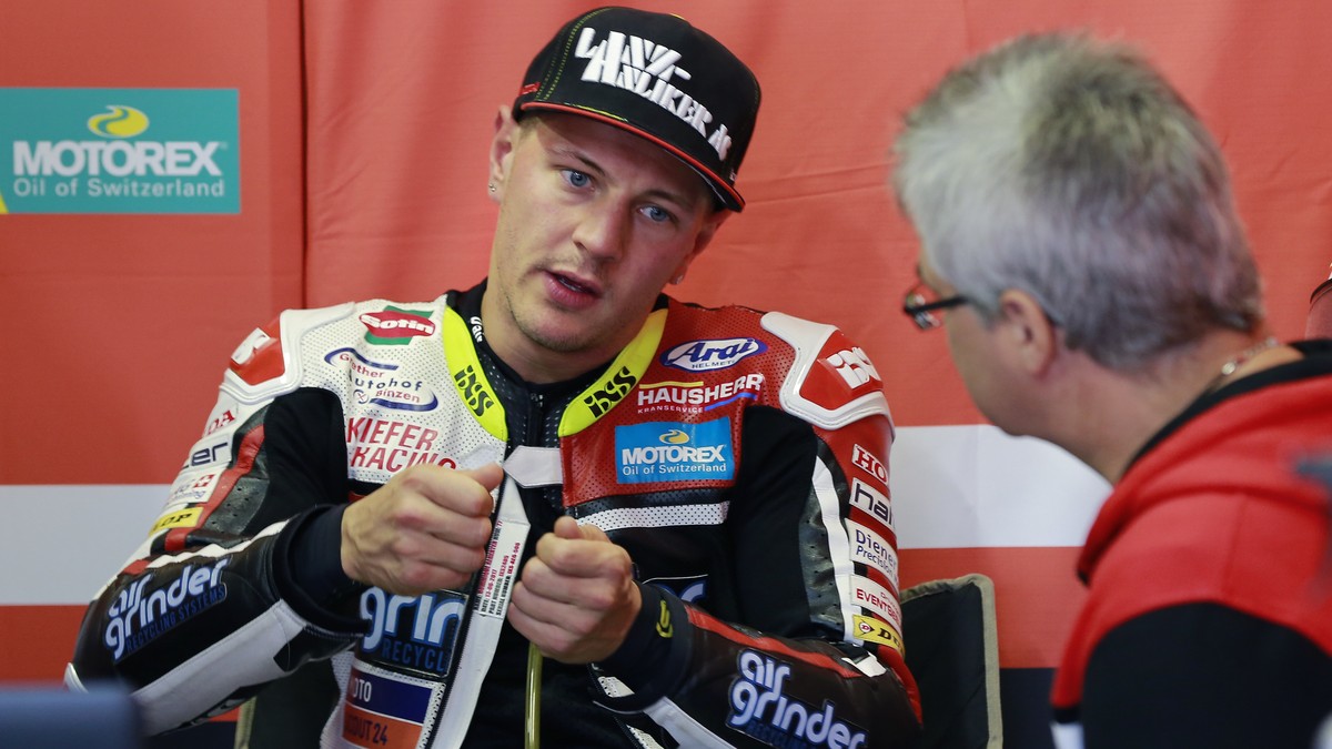 Moto2 rider Dominique Aegerter of Switzerland talks with his team staff during a free practice session for the MotoGP Japanese Motorcycle Grand Prix at the Twin Ring Motegi circuit in Motegi, north of ...