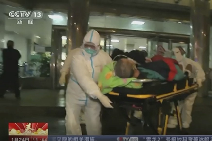 In this Thursday, Jan. 23, 2020, image from China's CCTV video, a patient is carried on a stretcher to an ambulance by medical workers in protective suits in Wuhan, China. China is swiftly buildi ...