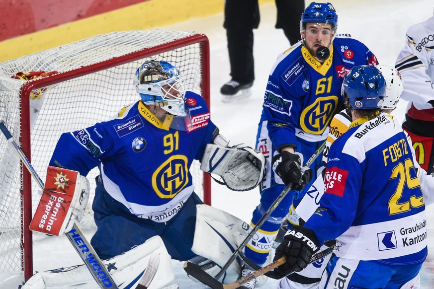 Torhueter Gilles Senn, Fabian Heldner und Beat Forster von Davos, sowie Diego Kostner von Lugano, von links beobachten den Puck, beim Meisterschaftsspiel der National League A zwischen dem HC Davos un ...