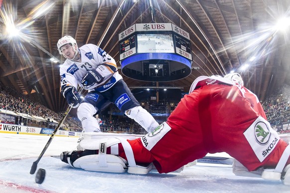 epa07249393 Magnitogorsk`s Roman Lyubimov, left, scores a penalty versus Ocelari Trinec&#039;s Petr Kvaca, during the game between HC Ocelari Trinec and HK Metallurg Magnitogorsk, at the 92nd Spengler ...