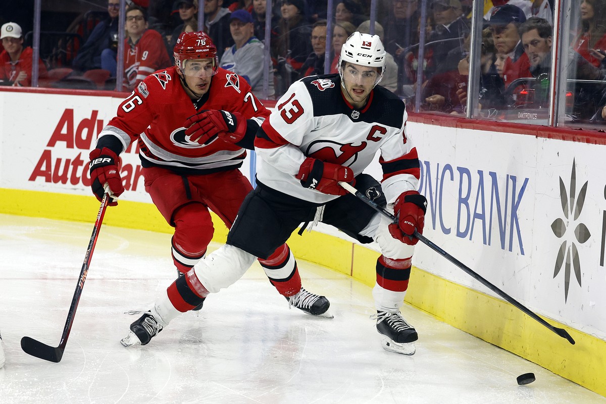 New Jersey Devils' Nico Hischier (13) controls the puck with Carolina Hurricanes' Brady Skjei closing in during the third period of an NHL hockey game in Raleigh, N.C., Tuesday, Dec. 20, 202 ...