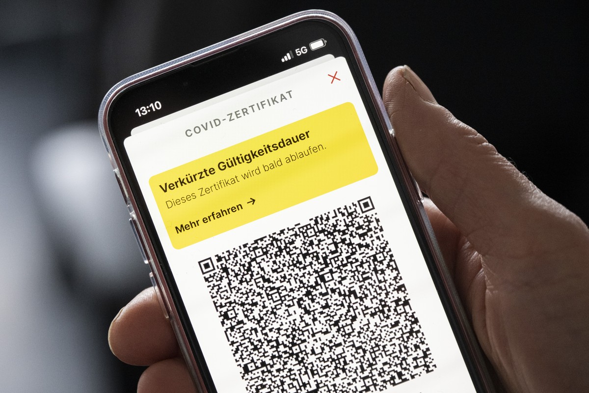 Eine Frau haelt ihr Mobiltelefon mit einer Meldung der Verkuerzten Gueltigkeitsdauer "Dieses Zertifikat wird bald ablaufen" in der Hand, aufgenommen am Donnerstag, 3. Februar 2022 in Zuerich ...