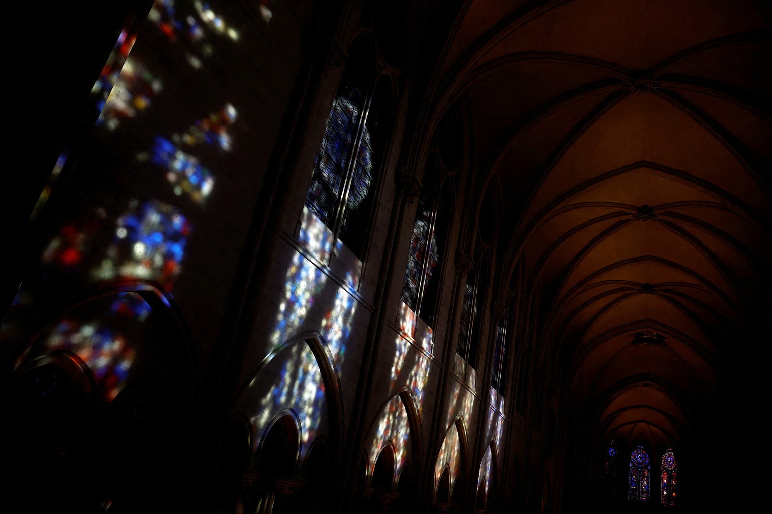 epa11747911 A view shows light from stained glass windows reflecting off a wall in the Notre-Dame de Paris cathedral in Paris, France, 29 November 2024. French President Macron is visiting the cathedr ...