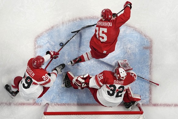 Russian Olympic Committee&#039;s Pavel Karnaukhov (15) and Denmark&#039;s Morten Madsen (29) go for the puck in front of Denmark goalkeeper Sebastian Dahm during a men&#039;s quarterfinal hockey game  ...