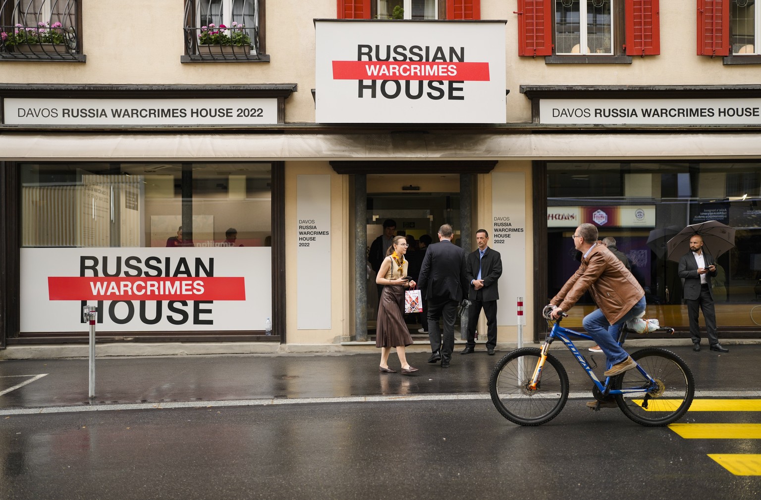 People gather in front of the so-called Russian War Crimes House alongside the World Economy Forum in Davos, Switzerland, Sunday, May 22, 2022. An exhibition with pictures documenting suspected Russia ...