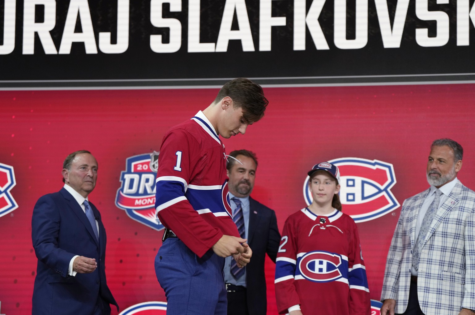 Juraj Slafkovsky puts on a Montreal Canadiens jersey after being selected as the top pick in the NHL hockey draft in Montreal on Thursday, July 7, 2022. Canadiens President and co-owner Geoff Molson i ...