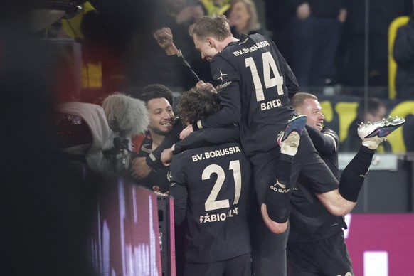 epa12839698 Ramy Bensebaini of Dortmund celebrates with teammates after scoring the 3-2 goal during the German Bundesliga soccer match between Borussia Dortmund and Hamburger SV in Dortmund, Germany,  ...