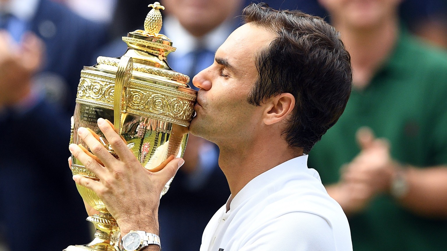 epa06091242 Roger Federer of Switzerland kisses the championship trophy following his victory over Marin Cilic of Croatia in the men&#039;s final of the Wimbledon Championships at the All England Lawn ...