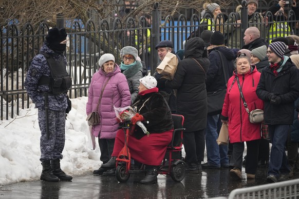 A police officer guards as people gather at the Church of the Icon of the Mother of God, in Moscow, Russia, Friday, March 1, 2024. Relatives and supporters of Alexei Navalny are bi...