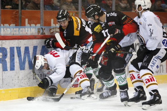 Luganos Taylor Chorney, Berns Andre Heim Berns Alain Berger und Luganos Romain Loeffel, von links, kaempfen um den Puck, im Eishockey Meisterschaftsspiel der National League zwischen dem SC Bern und d ...