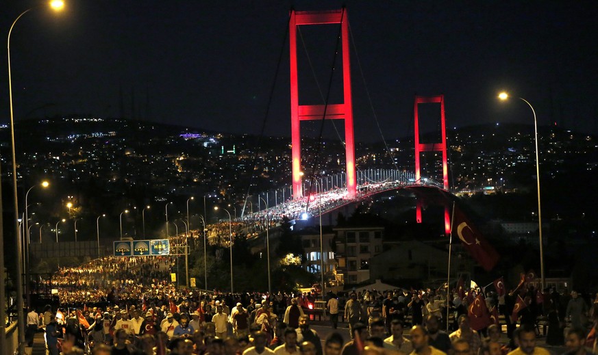 epa05435659 Supporters of Turkish President Recep Tayyip Erdogan hold Turkish flags at Bosphorus Bridge during a demonstration against the failed coup in Istanbul, Turkey 21 July 2016. Turkish Preside ...