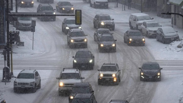 Vehicles drive in downtown Minneapolis as snow falls, Tuesday, Feb. 21, 2023. A winter storm took aim at the Upper Midwest on Tuesday, threatening to bring blizzard conditions, bitterly cold temperatu ...