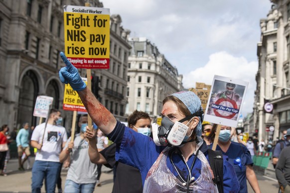 A protestor gestures as NHS staff and supporters march on Regent Street as part of a series of marches and rallies taking place across the country calling for a 15 percent pay rise for NHS workers and ...