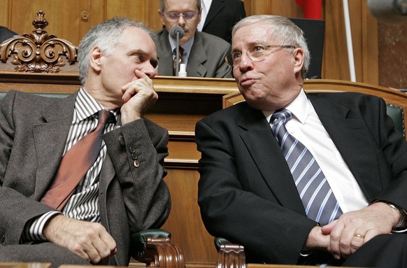 Bundesrat Christoph Blocher, rechts, diskutiert mit seinem Regierungskollegen Moritz Leuenberger zu Beginn der Sitzung der Vereinigten Bundesversammlung am Mittwoch, 12. Dezember 2007, im Bundeshaus i ...