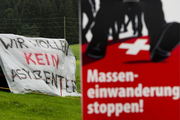 ARCHIV - SVP Plakat gegen die Masseneinwanderung und ein Transparent gegen das im ehemaligen Buergerheim Mettmenegg, etwas ausserhalb des Dorfes Fischbach LU, geplante Asylzentrum fuer rund 55 Asylsuc ...