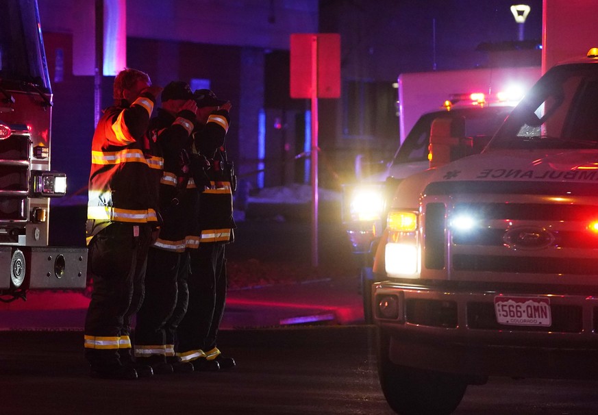 Firefighters salute an ambulance as it leaves a King Soopers grocery store where authorities say multiple people have been killed in a shooting, Monday, March 22, 2021, in Boulder, Colo. (AP Photo/Dav ...