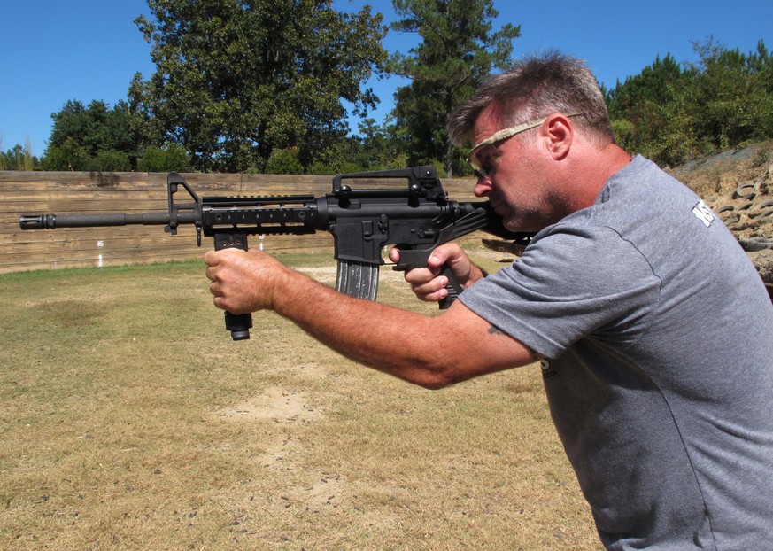 Shooting instructor Frankie McRae aims an AR-15 rifle fitted with a &quot;bump stock&quot; at his 37 PSR Gun Club in Bunnlevel, N.C., on Wednesday, Oct. 4, 2017. The stock uses the recoil of the semia ...