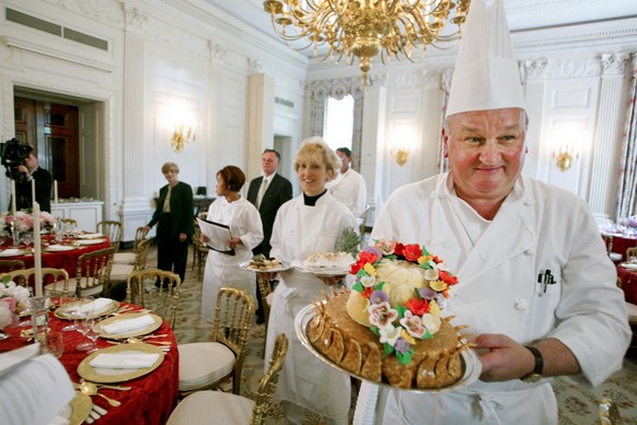 FILE - White House pastry chef Roland Mesnier, right, displays a mango coconut lei, the dessert for the dinner hosted by President George W. Bush for Philippine President Gloria Macapagal Arroyo, in t ...