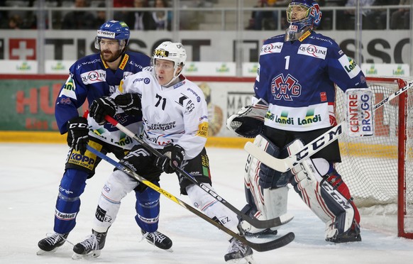 Fribourgs Killian Mottet, Mitte, im Kampf mit Biels Thomas Wellinger vor dem Tor von Biels Torhueter Jonas Hiller, im Eishockey Meisterschaftsspiel der National League A zwischen dem EHC Biel und dem  ...